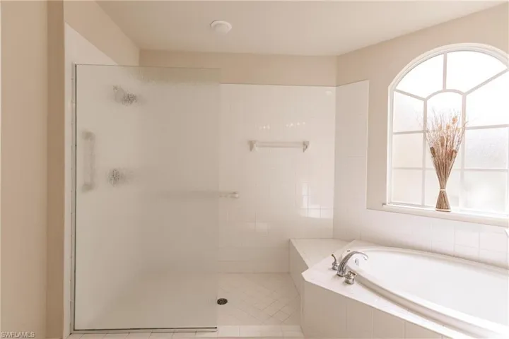 Bathroom featuring a healthy amount of sunlight, independent shower and bath, and tile flooring
