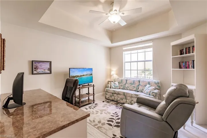 Living room featuring ceiling fan and a tray ceiling