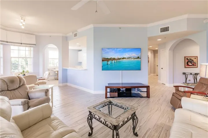Living room featuring ceiling fan, light hardwood / wood-style flooring, and crown molding
