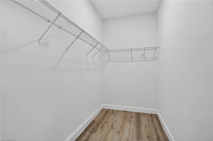 Walk in closet with light wood-style floors