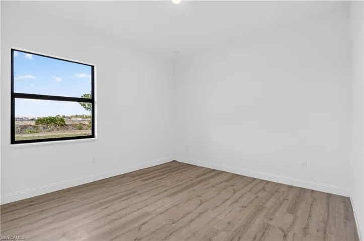 Spare room featuring light wood finished floors and baseboards