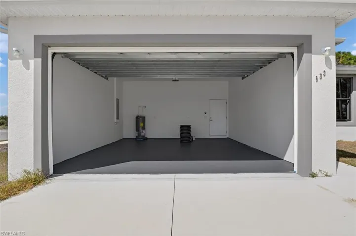 Garage with driveway and water heater
