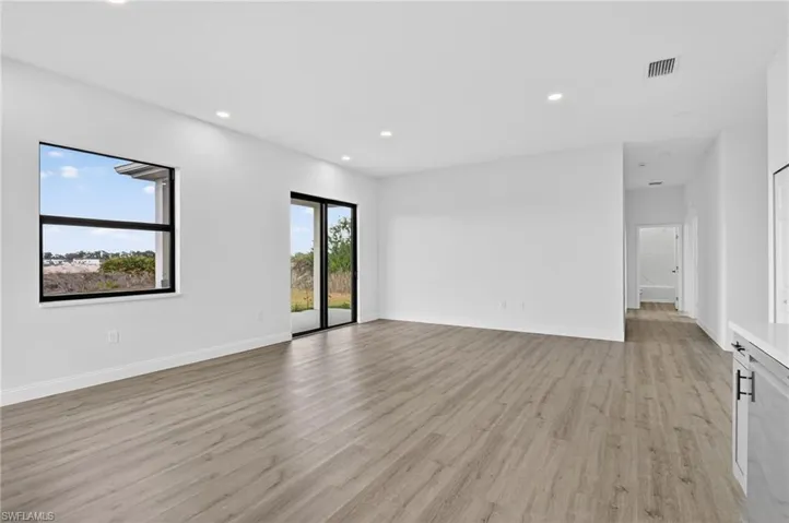 Empty room with light wood-style flooring and recessed lighting