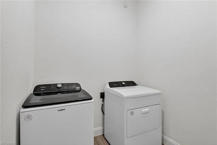 Laundry area with washer and dryer and light wood-style flooring