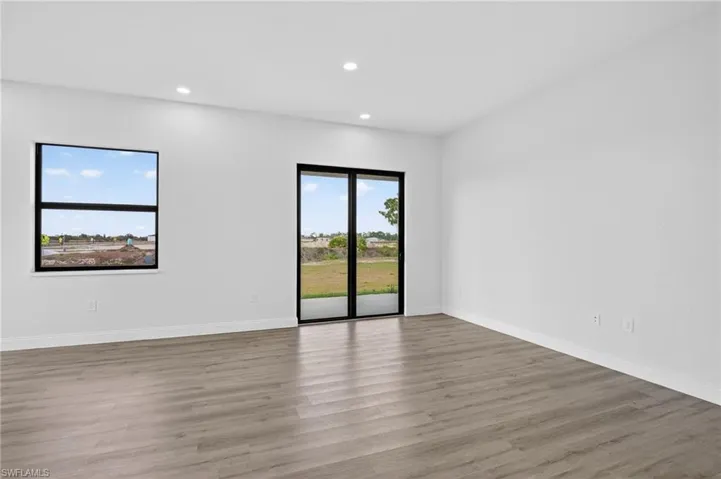 Unfurnished room with wood finished floors and recessed lighting