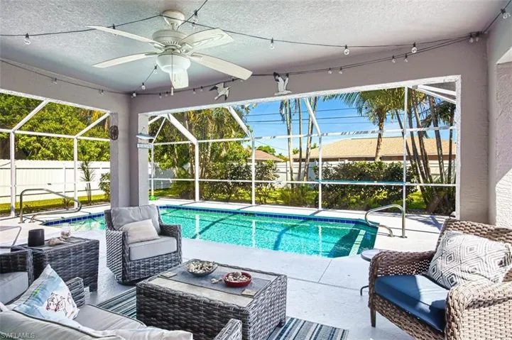 View of swimming pool with a fenced backyard, glass enclosure, an outdoor living space, and a patio area