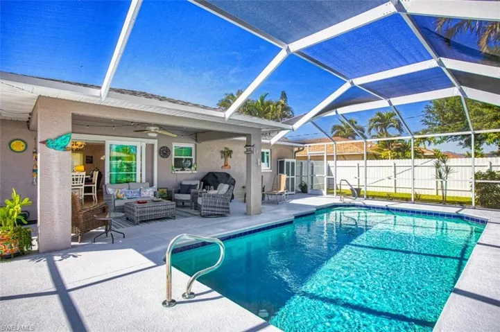 View of pool with a lanai, fence, a fenced in pool, outdoor lounge area, and a patio area