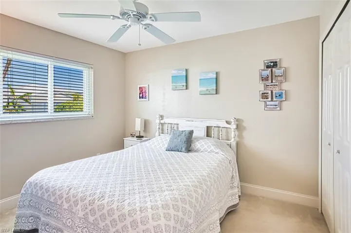 Bedroom featuring a closet, a ceiling fan, baseboards, and carpet