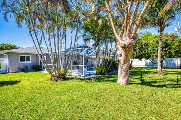 View of yard featuring glass enclosure and fence