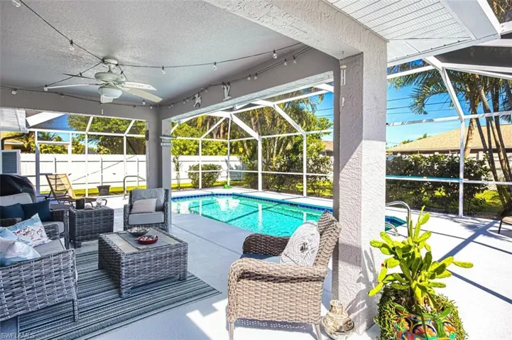 View of pool with an outdoor living space, glass enclosure, a fenced backyard, and a patio area