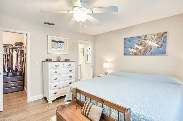 Bedroom featuring a closet, visible vents, light wood finished floors, a ceiling fan, and a spacious closet