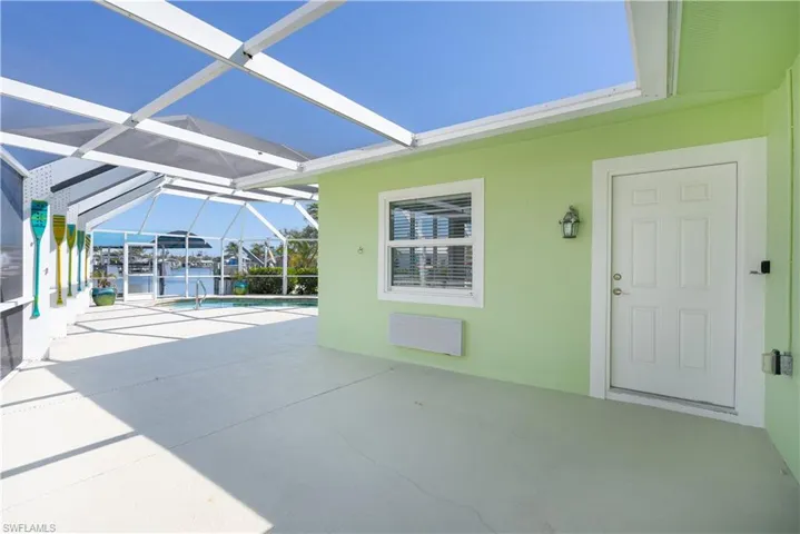 View of patio with an outdoor pool, a water view, and a lanai.