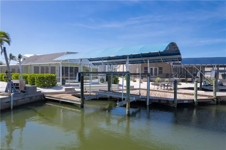 Dock area with a lanai and a water view.