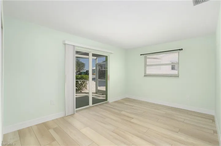 Bedroom featuring vinyl wood finished floors, pool access and a healthy amount of sunlight