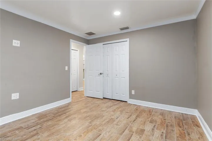 Unfurnished bedroom with light hardwood / wood-style flooring, a closet, and ornamental molding