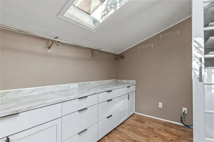 Walk in closet featuring wood-type flooring and a skylight