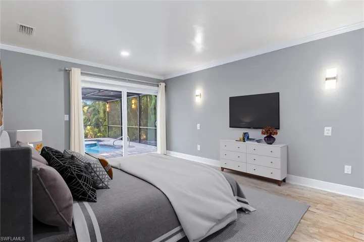 Bedroom with access to exterior, crown molding, and light hardwood / wood-style flooring