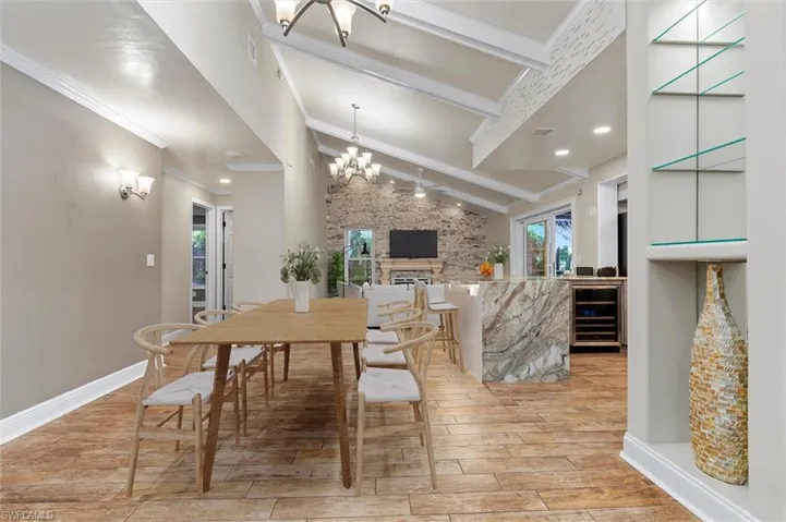 Dining space with plenty of natural light, light hardwood / wood-style floors, a fireplace, and a chandelier