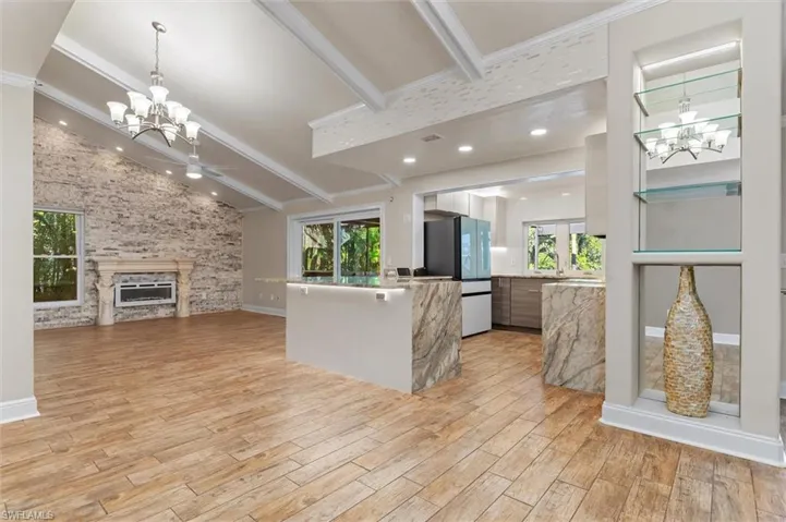 Kitchen with a fireplace, white refrigerator, light hardwood / wood-style floors, and a wealth of natural light