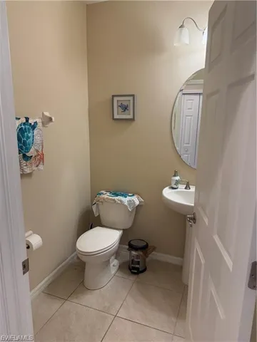 Half bath featuring toilet and light tile patterned flooring