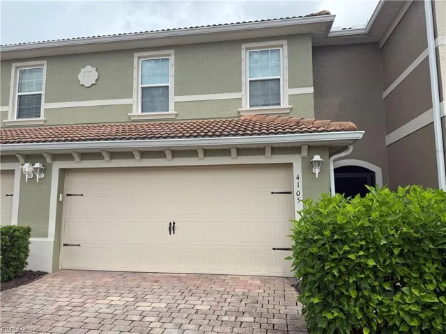 View of front of house featuring stucco siding, decorative driveway, and an attached garage