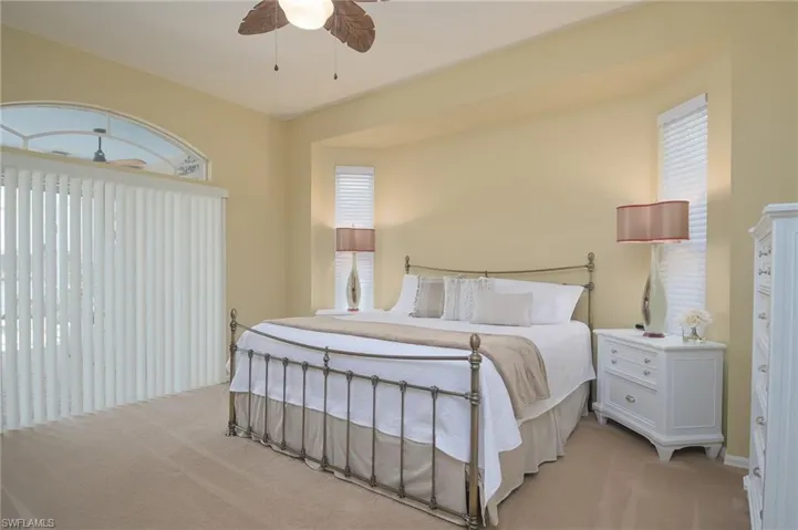 Carpeted bedroom featuring ceiling fan