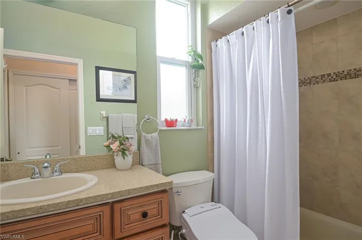 Full bathroom featuring shower / tub combo, toilet, and vanity