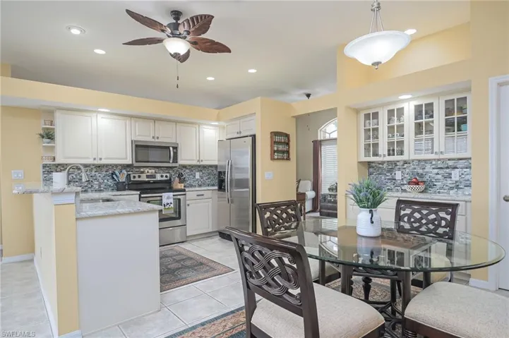 Kitchen with light tile floors, tasteful backsplash, and appliances with stainless steel finishes