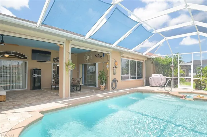View of pool with a patio area, glass enclosure, an in ground hot tub, and ceiling fan