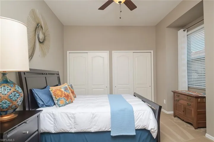 Carpeted bedroom with two closets and ceiling fan