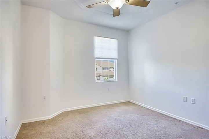 Empty room featuring carpet flooring and a ceiling fan