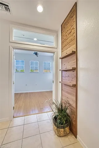 Corridor featuring baseboards and light tile patterned flooring