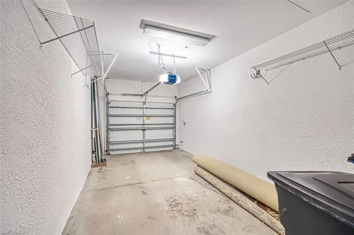 Garage with a textured wall and a garage door opener