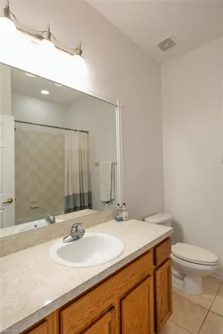 Full bathroom featuring light tile patterned floors, a shower with curtain, and vanity