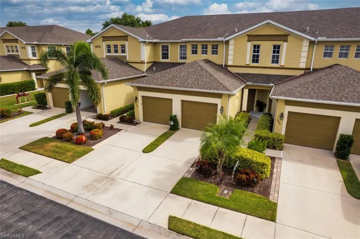 Traditional-style home with stucco siding, driveway, and a shingled roof