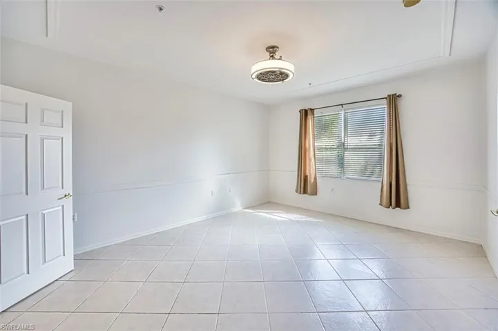 Empty room with light tile patterned floors and baseboards