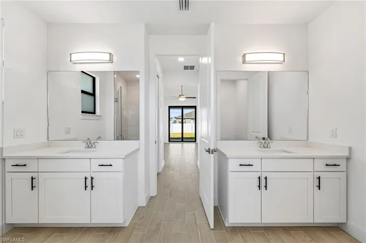 Bathroom with ceiling fan and double sink vanity