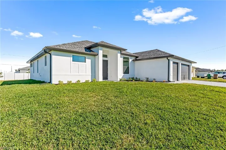 View of front of home featuring a front lawn and a garage