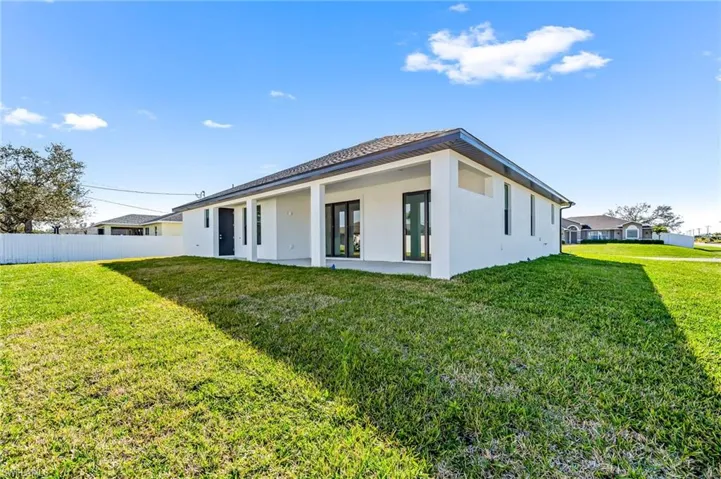 Back of property featuring a yard