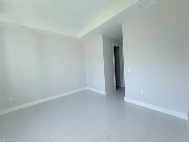 Spare room with baseboards and light tile patterned flooring