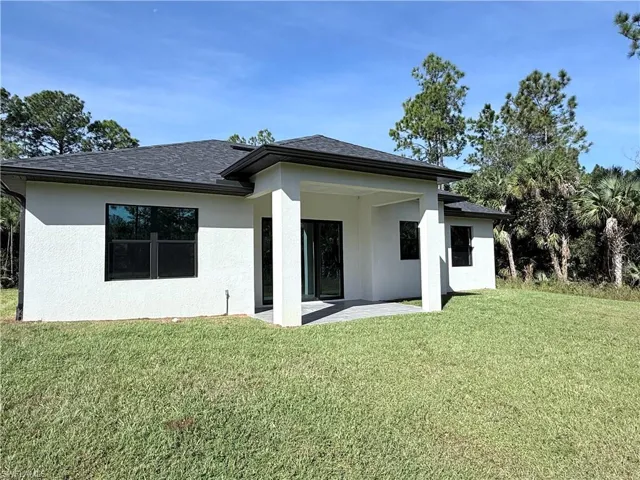 Back of property featuring a patio, stucco siding, and a lawn