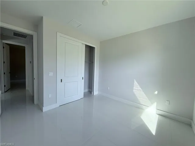 Unfurnished bedroom with light tile patterned flooring and a closet
