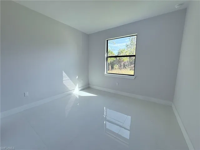 Empty room with tile patterned floors and baseboards