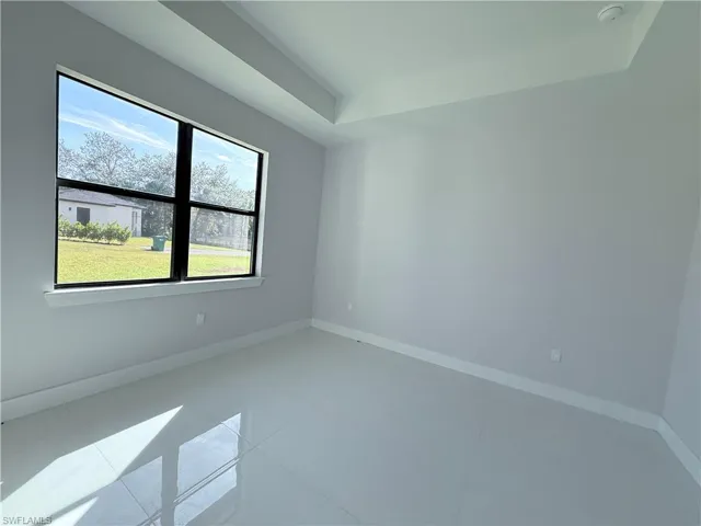 Spare room featuring baseboards and tile patterned floors
