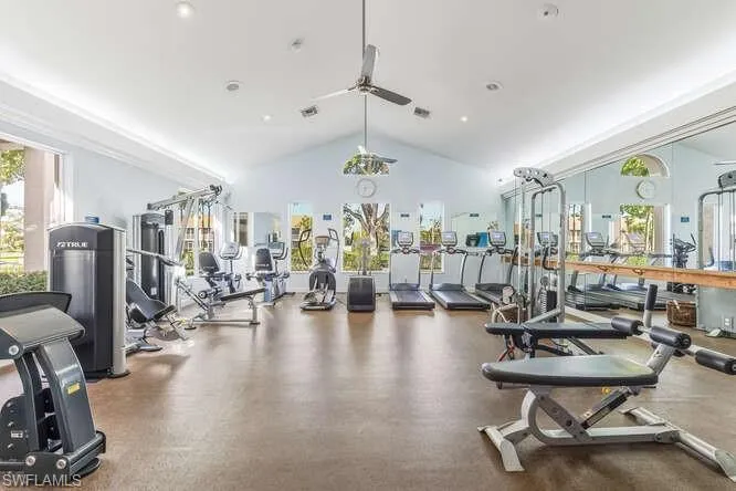 Exercise room featuring high vaulted ceiling and a ceiling fan.