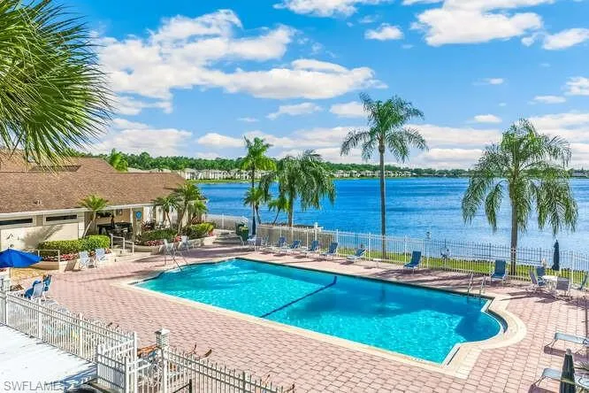Community pool with a patio and a water view.