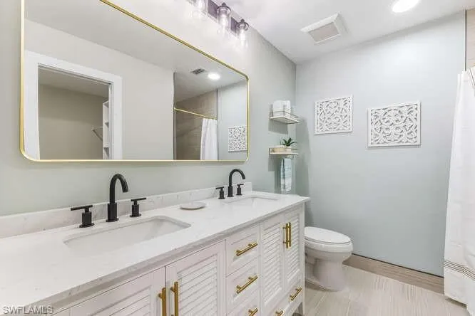 Updated Master Bathroom featuring double vanity, new tile flooring, walk-in shower, and recessed lighting.