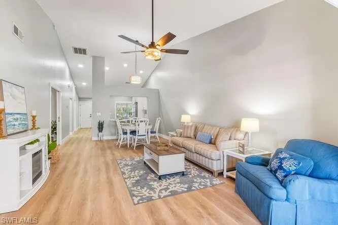 Living area featuring new LVT flooring, recessed lighting, a ceiling fan, and high vaulted ceiling.