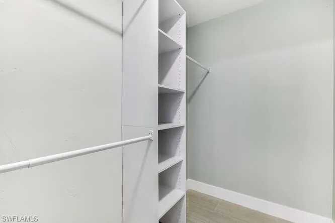 Spacious walk-in closet with fresh paint, new LVT flooring and built-in storage/closet system