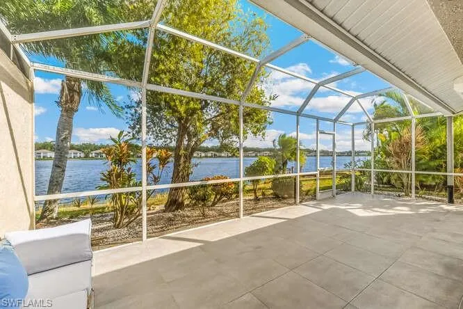 Screened lanai featuring new tile flooring, electric storm shutter, ceiling fan and a water view.